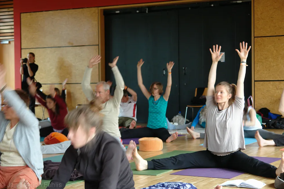 Yogaklasse mit erhobenen Armen