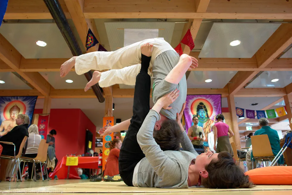 Acro-Yoga: Partnerin wird auf den Füßen balanciert